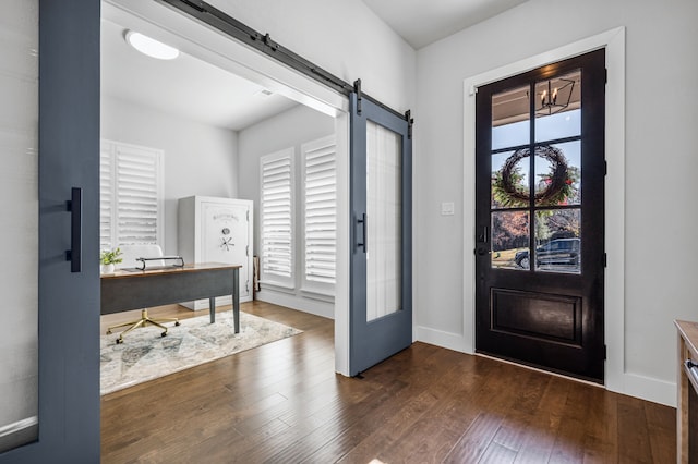 entrance foyer with a barn door, dark wood-type flooring, and french doors