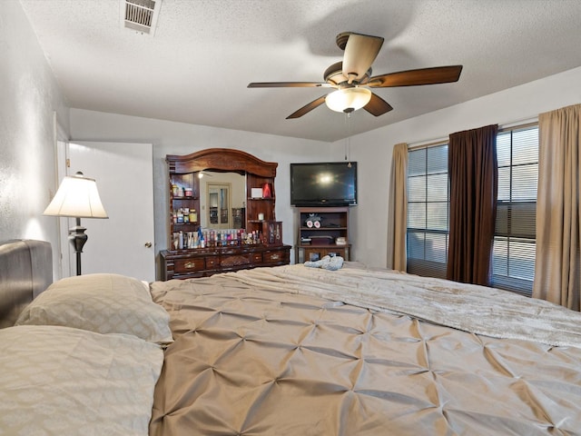 bedroom featuring ceiling fan and a textured ceiling