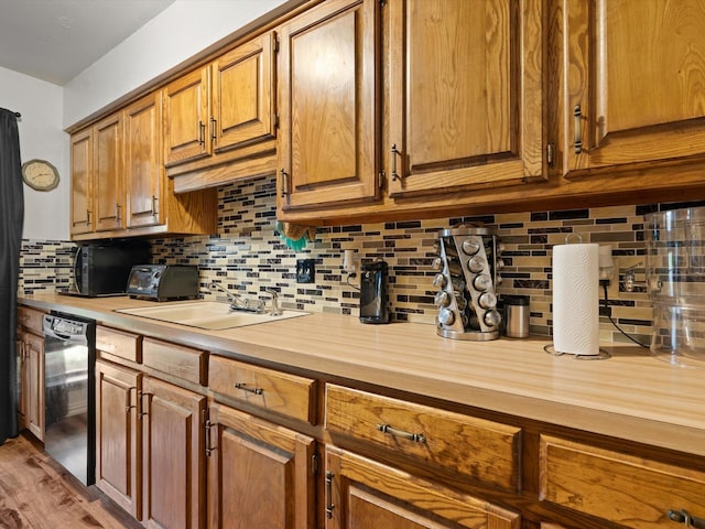 kitchen with butcher block countertops, decorative backsplash, dishwasher, and sink