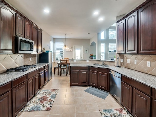 kitchen featuring pendant lighting, sink, appliances with stainless steel finishes, and tasteful backsplash