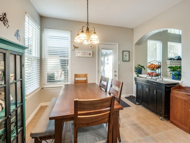 dining area featuring a notable chandelier, light tile patterned flooring, and plenty of natural light