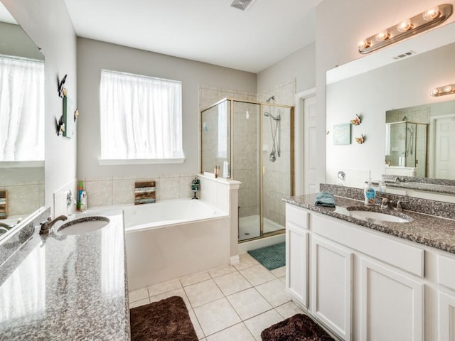 bathroom featuring tile patterned flooring, vanity, and plus walk in shower