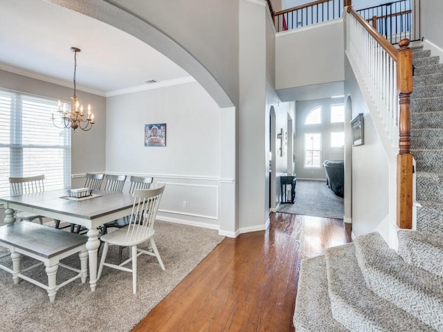 dining area featuring hardwood / wood-style floors, a notable chandelier, and ornamental molding