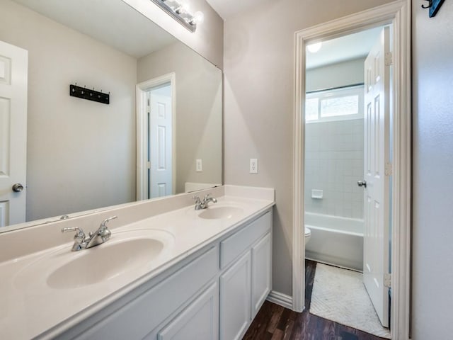 full bathroom featuring hardwood / wood-style flooring, vanity, toilet, and bathtub / shower combination