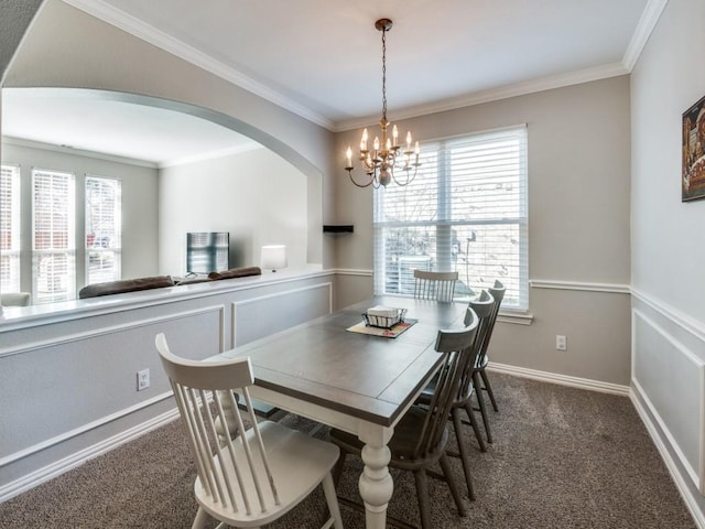 carpeted dining room with a chandelier and ornamental molding