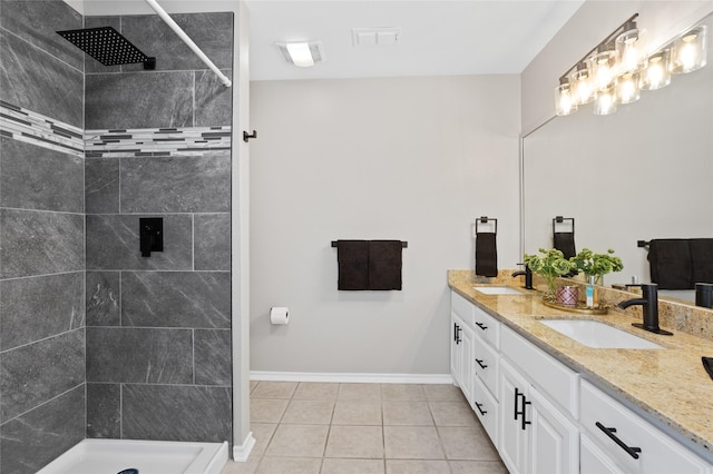 bathroom featuring tile patterned floors, vanity, and a tile shower