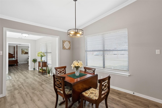 dining area with lofted ceiling, ornamental molding, and light hardwood / wood-style floors