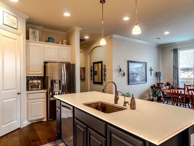 kitchen with sink, stainless steel appliances, ornamental molding, a center island with sink, and decorative light fixtures