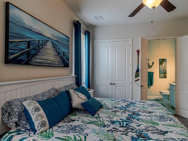 bedroom with ceiling fan, ensuite bathroom, carpet floors, and a closet