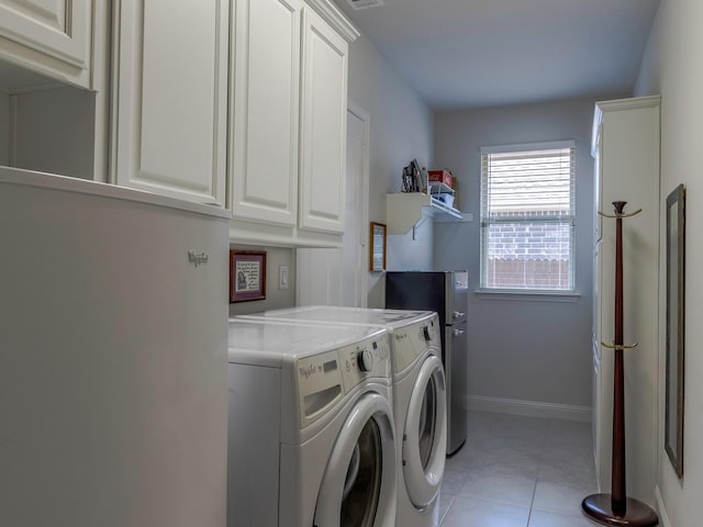 washroom with cabinets, washing machine and dryer, and light tile patterned flooring