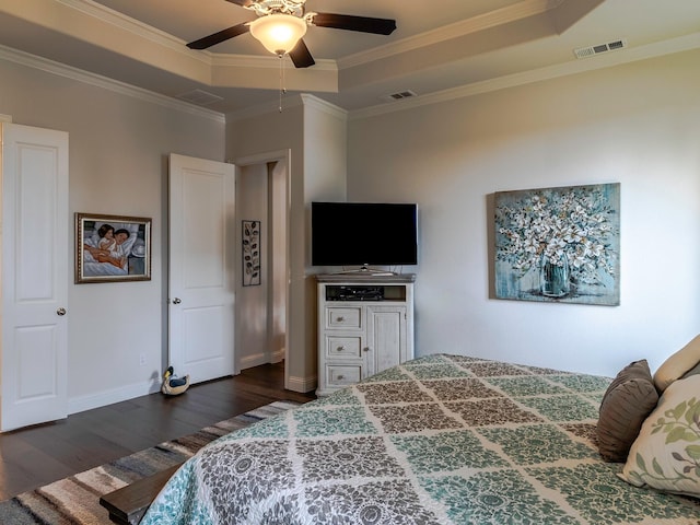 bedroom featuring dark wood-type flooring, ceiling fan, crown molding, and a raised ceiling