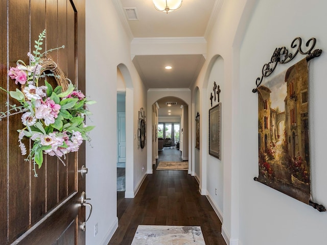 hall with dark wood-type flooring and ornamental molding