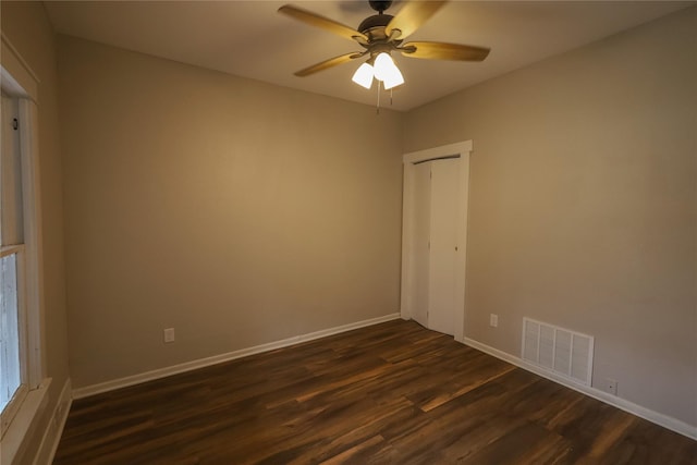 spare room with ceiling fan and dark wood-type flooring