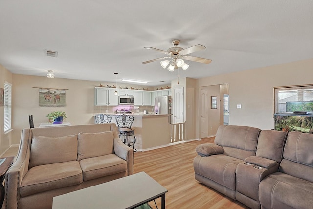 living room with ceiling fan and light hardwood / wood-style floors