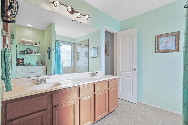 bathroom featuring tile patterned floors, vanity, and a tile shower