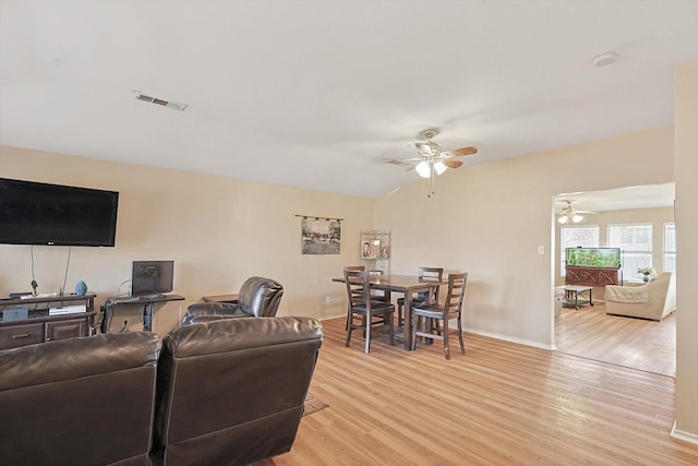 living room featuring ceiling fan, light hardwood / wood-style floors, and vaulted ceiling