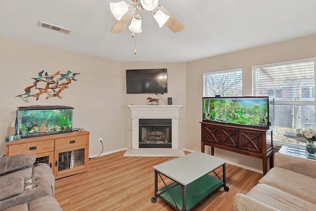 living room featuring wood-type flooring and ceiling fan