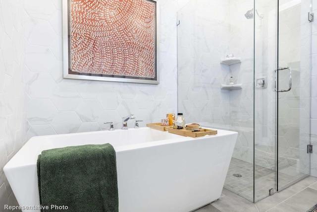 bathroom featuring plus walk in shower and tile walls