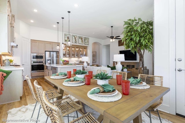 dining area with light hardwood / wood-style flooring and ceiling fan