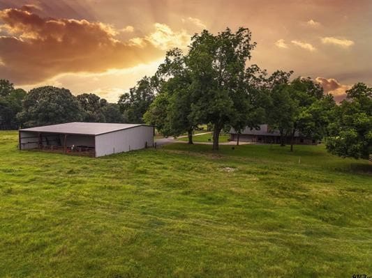 yard at dusk featuring an outbuilding