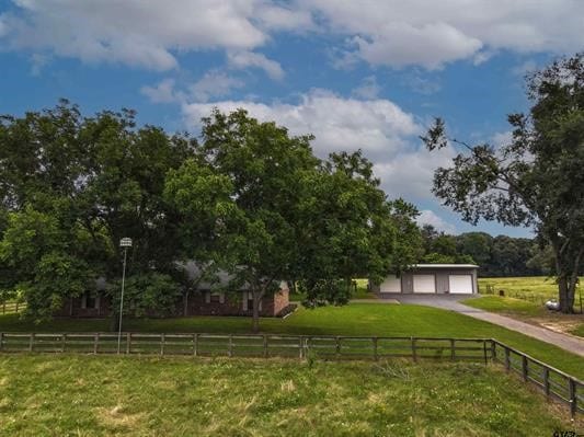 view of yard with a rural view, a garage, and an outdoor structure