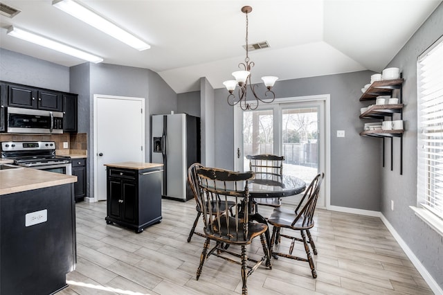 dining space featuring light hardwood / wood-style flooring, lofted ceiling, and an inviting chandelier