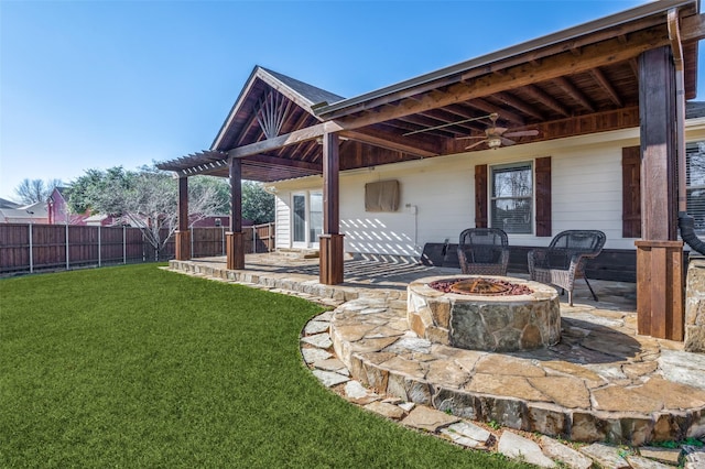 view of patio featuring ceiling fan and a fire pit