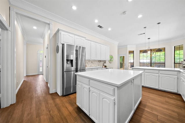 kitchen featuring a center island, stainless steel refrigerator with ice dispenser, backsplash, pendant lighting, and white cabinets