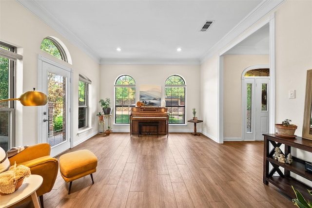 sitting room featuring wood-type flooring and ornamental molding