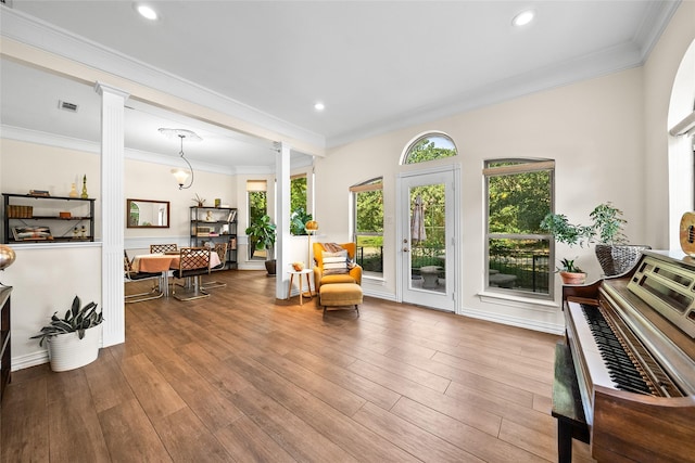 living area featuring hardwood / wood-style flooring, ornamental molding, and decorative columns