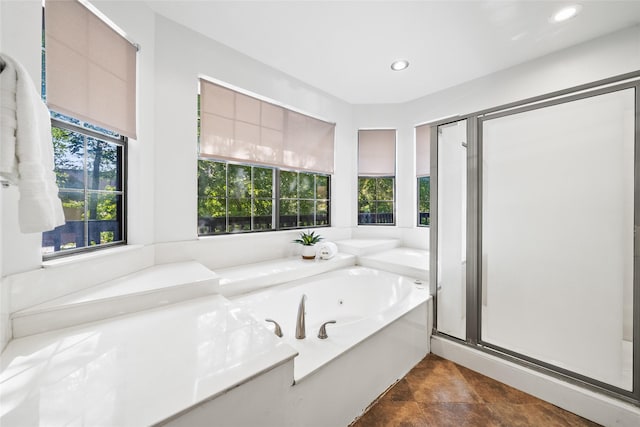 bathroom with shower with separate bathtub and a wealth of natural light