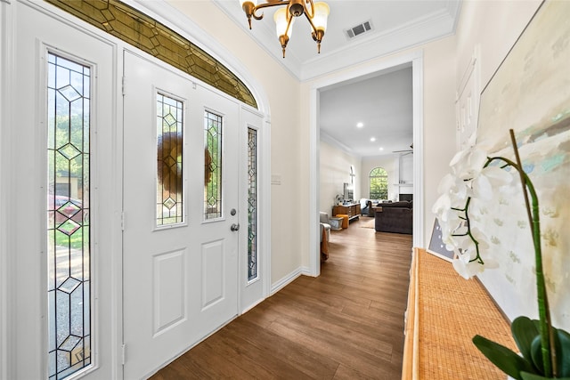 foyer entrance featuring ceiling fan with notable chandelier, wood-type flooring, and ornamental molding