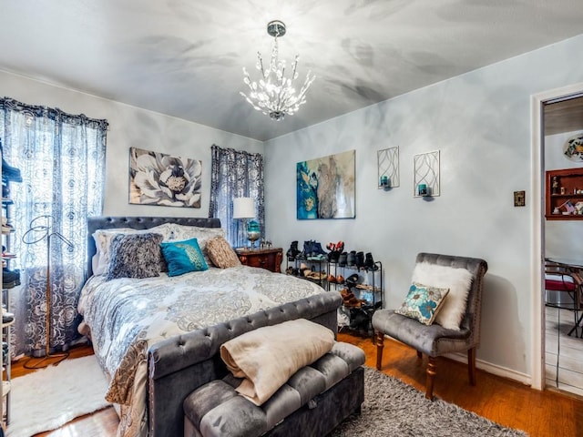 bedroom featuring hardwood / wood-style floors and an inviting chandelier