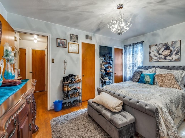 bedroom featuring a chandelier, a closet, and light hardwood / wood-style floors