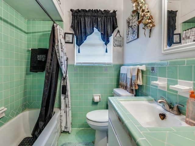 full bathroom with vanity, toilet, tile walls, and shower / bath combo with shower curtain