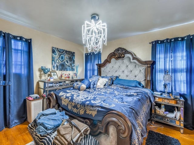 bedroom with hardwood / wood-style flooring and a notable chandelier