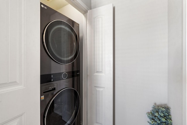 clothes washing area featuring stacked washer / drying machine