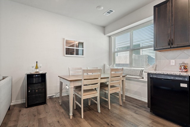 dining space with dark wood-type flooring and beverage cooler