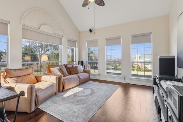 living area featuring dark wood-type flooring, a healthy amount of sunlight, ceiling fan, and high vaulted ceiling