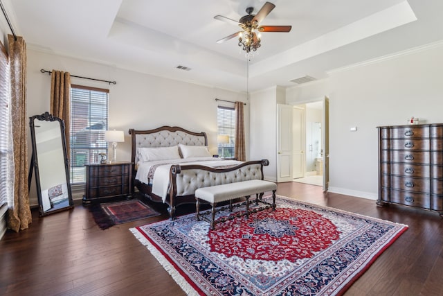 bedroom with visible vents, hardwood / wood-style flooring, and a tray ceiling