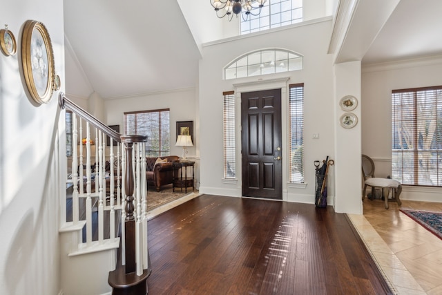 entryway featuring a healthy amount of sunlight, hardwood / wood-style flooring, high vaulted ceiling, and stairs