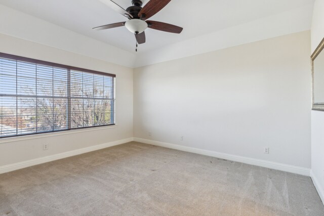 empty room featuring ceiling fan, baseboards, and light carpet