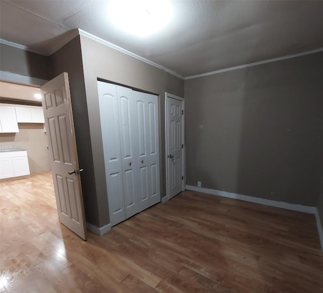 unfurnished bedroom featuring crown molding and wood-type flooring