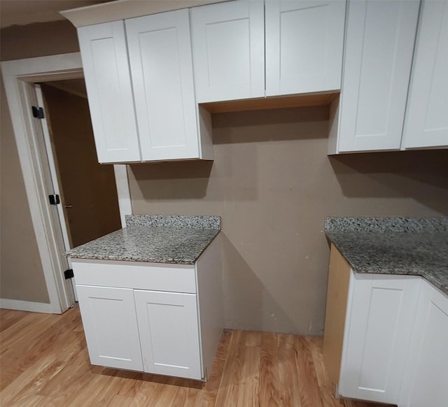 kitchen featuring white cabinets and stone countertops