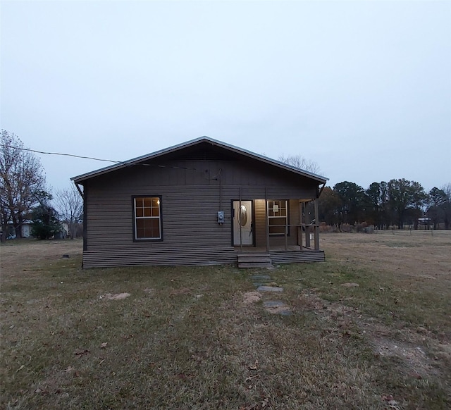 exterior space with covered porch and a yard