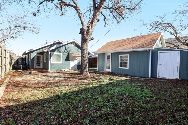 rear view of house featuring a yard and a shed