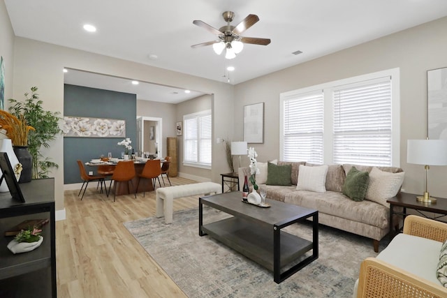 living room with ceiling fan and light wood-type flooring