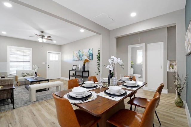 dining space with ceiling fan and light wood-type flooring