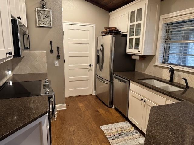 kitchen with stainless steel appliances, white cabinetry, tasteful backsplash, and sink