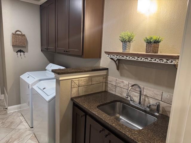 washroom with cabinets, separate washer and dryer, and sink